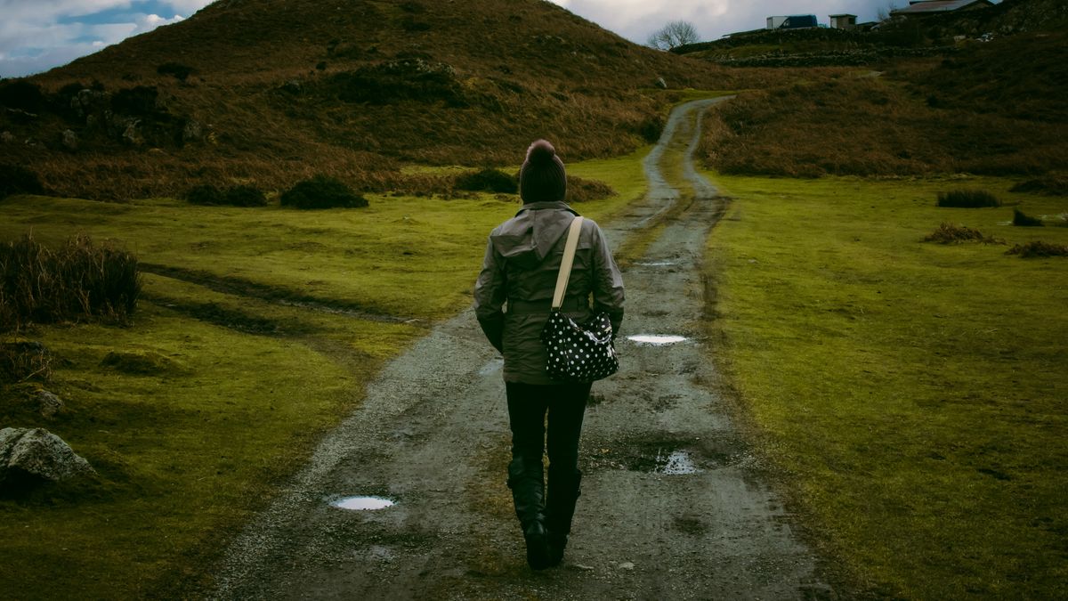 Mujer caminando por un sendero en el campo durante su recuperación