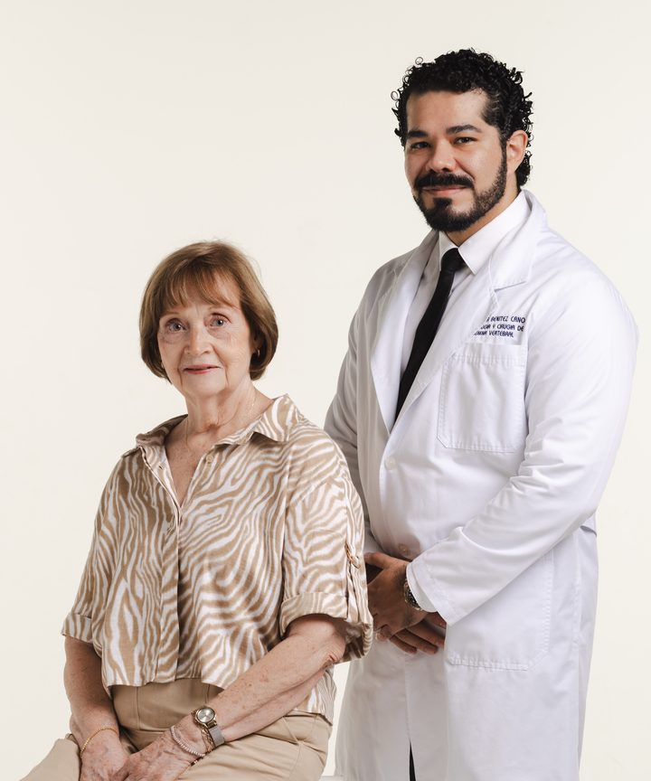 El Dr. Víctor Benítez Cano con una paciente adulta mayor sentada